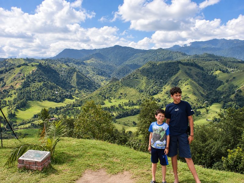 Juanes y Danny en un mirador, con las montañas verdes de la Cordillera Central al fondo