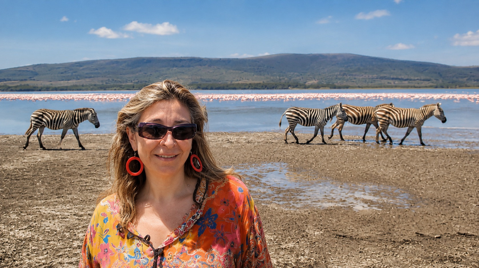 Alexandra en la orilla del Lago Nakuru, con cebras y una nube de flamencos rosados al fondo