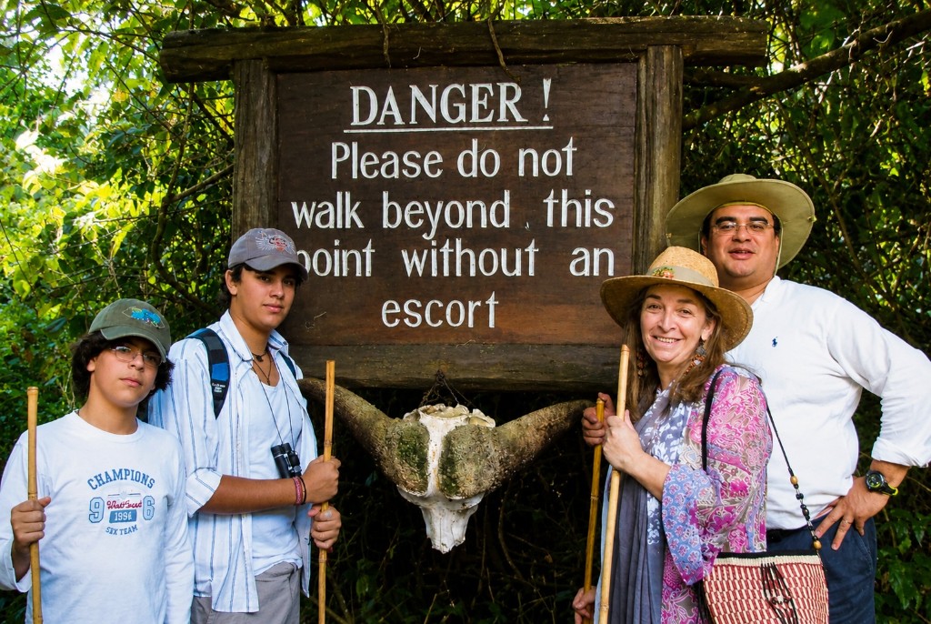 Danny, Juanes, Alexandra y Jairo junto al aviso de peligro del Mount Kenia National Park, con un cráneo de búfalo bajo el letrero