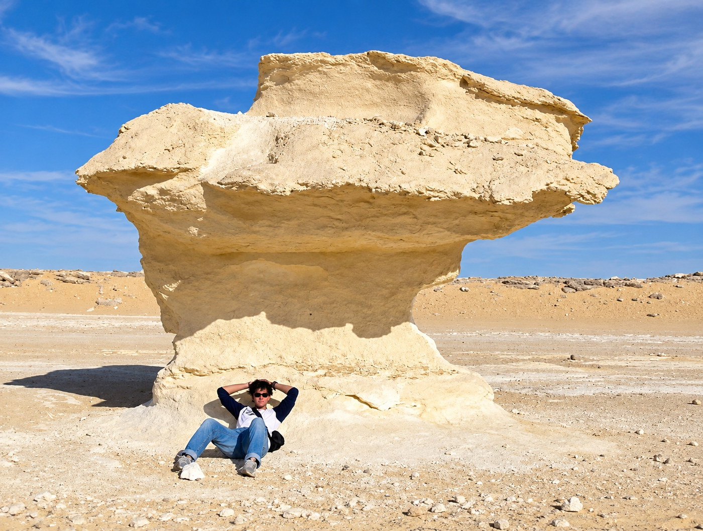 Formación de piedra caliza en forma de seta en el Desierto Blanco, con Juanes recostado a su sombra